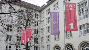 Vier gehisste Flaggen vor der dem Eingang an der HWR Berlin. 